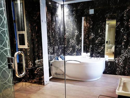 布赖代شاليه بالم ون الفندقي的带浴缸、水槽和镜子的浴室