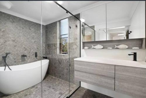 悉尼Manly family executive apartment的带浴缸和盥洗盆的浴室