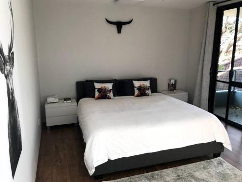 悉尼Manly family executive apartment的卧室配有一张带两个枕头的大白色床