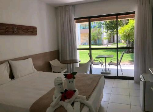 拉巴拉德纳圣米格尔Excelente Acomodação no Paraíso das Águas, Studio no Resort ILOA em Alagoas的酒店客房设有一张床铺和一张桌子,享有美景。