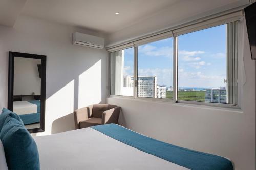 坎昆坎昆马勒孔套房公寓式酒店的一间卧室设有一张床和一个大窗户