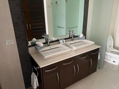 普拉亚卡门Brand New and Amazing Penthouse!的一间带两个盥洗盆和大镜子的浴室