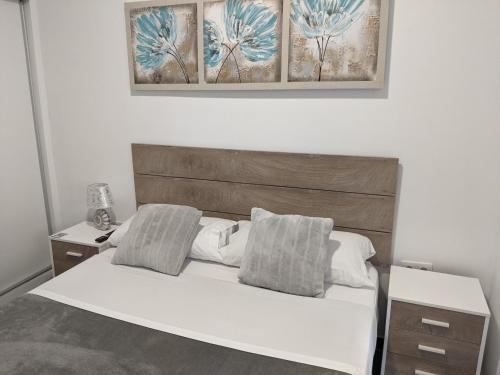 阿利坎特Pension Susita的卧室配有白色的床和木制床头板