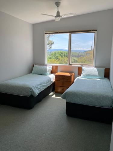 曼斯菲尔德燔溪小屋民宿的带窗户的客房内的两张床