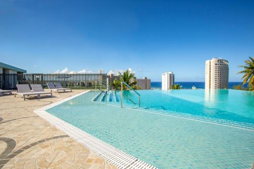 塔穆宁景湾关岛酒店的大楼顶部的大型游泳池