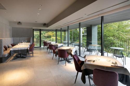 箱根HAKONE NICA的餐厅设有桌椅和大窗户。