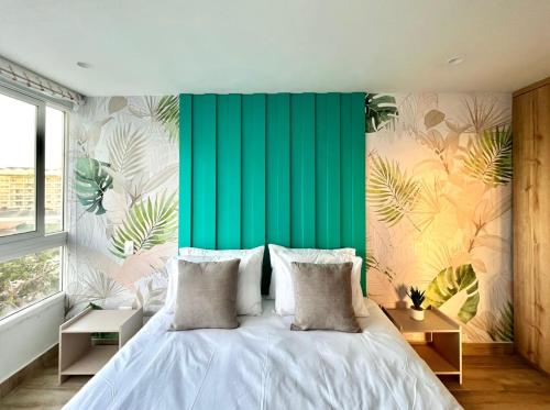 圣安德烈斯Apartamento Punta Hansa Norte的一间卧室配有一张带绿色墙壁的床