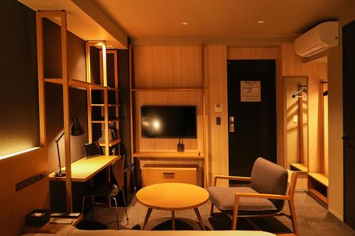 东京N+ Hotel 秋叶原的小房间设有书桌和桌椅
