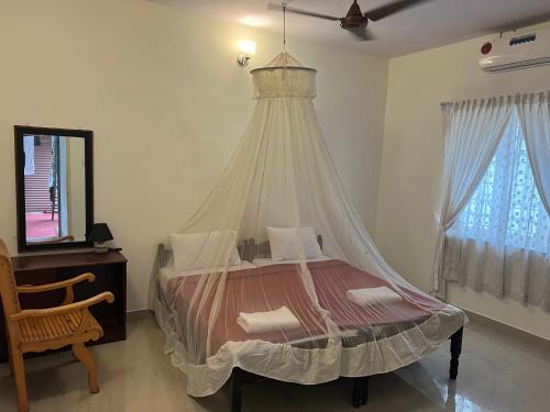 科钦Kuppath Inn的一间卧室配有一张带蚊帐的床