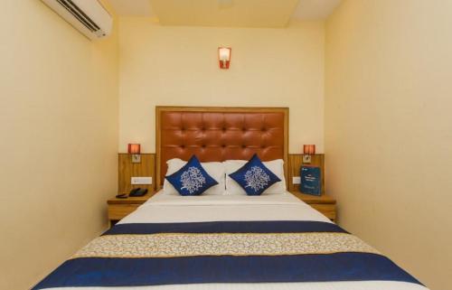 孟买Aster Hotel Near Mumbai Airport的一间卧室配有一张带蓝色枕头的大床
