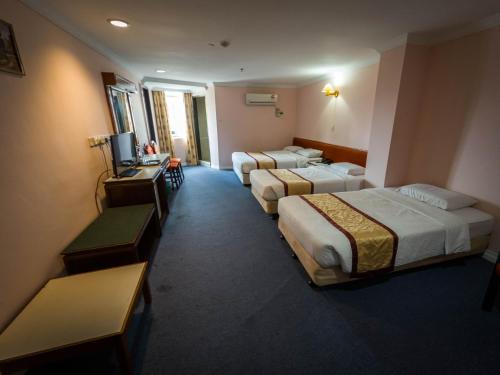 米里Miri Hotel的酒店客房设有两张床和电视。