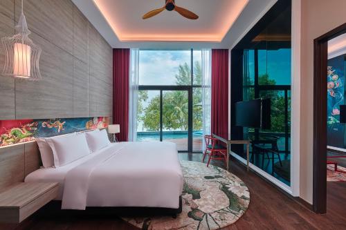峇都丁宜Angsana Teluk Bahang的卧室设有一张白色大床和大窗户