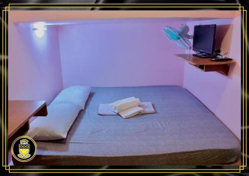 杜马格特White Knights Dumaguete的客房设有1张带电视和书桌的床。