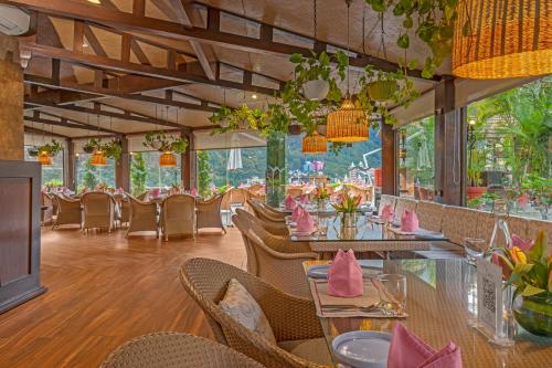 瑞诗凯诗Aloha On The Ganges by Leisure Hotels的餐厅配有桌椅和粉色餐巾