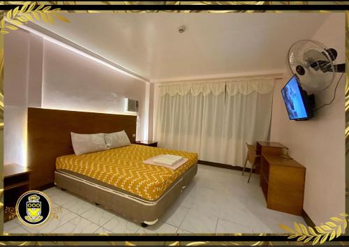 杜马格特White Knights Real的一间卧室配有一张床和一台电视