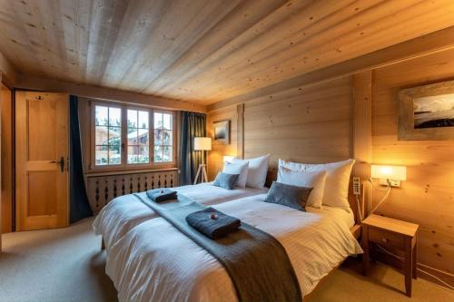 格施塔德Charming Alpine Apartment Gstaad的木制客房内的一间卧室配有一张大床