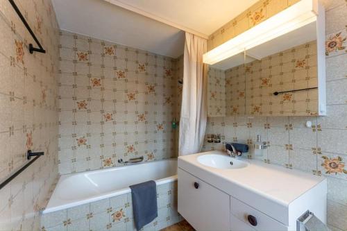 格施塔德Charming Alpine Apartment Gstaad的浴室配有盥洗盆和浴缸。