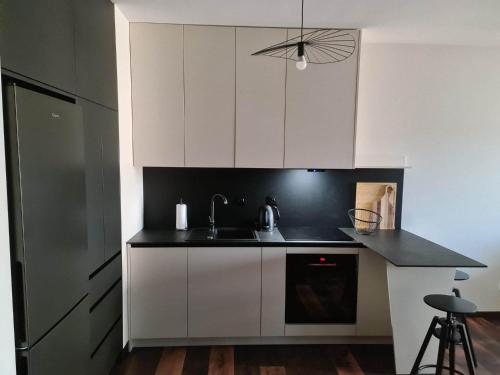 弗罗茨瓦夫Copper Apartment Free Parking的厨房配有白色橱柜和黑色台面