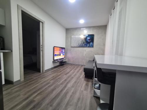 乌迪内Apartment Udine的一间空房间,配有电视,一间房间铺有硬木地板