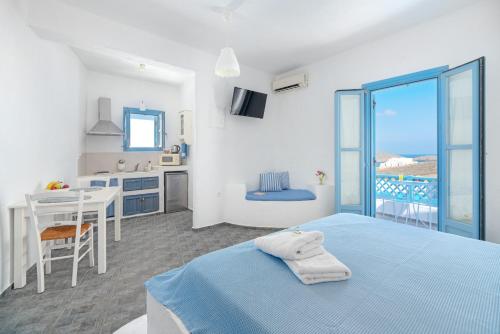 MaltezanaCastellano Village的白色的客房设有蓝色的床和厨房
