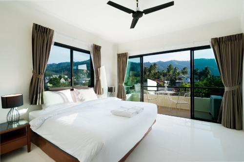 邦涛海滩Hill Myna Holiday Park & Cafe的卧室设有一张白色大床和大窗户
