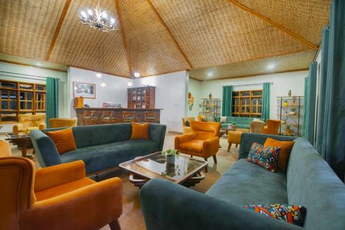 KisoroGorilla Leisure Lodge的客厅配有蓝色沙发和橙色椅子