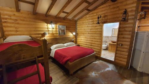 阿贝托内B&B Chalet的小木屋内一间卧室,配有两张床