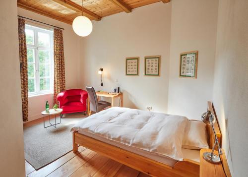 韦尔特卡拉蒙经济型酒店（客房&早餐）的一间卧室配有一张床、一张桌子和一把红色椅子