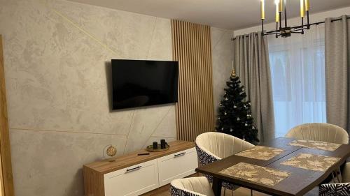 ZblewoApartament Złoty 4的一间设有桌子和圣诞树的用餐室