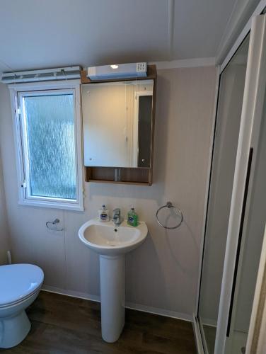 韦茅斯Caravan Littlesea Haven Weymouth Amazing Views的一间带水槽、卫生间和镜子的浴室