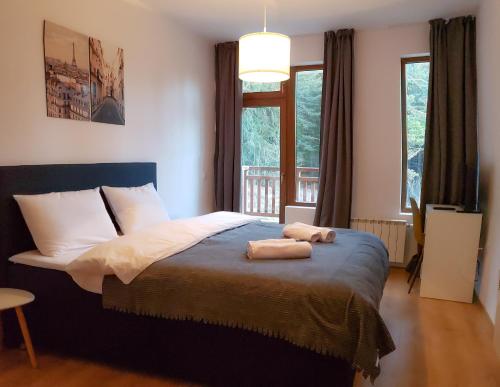 波罗维茨Semiramida Gardens Apartments的一间卧室配有一张床,上面有两条毛巾