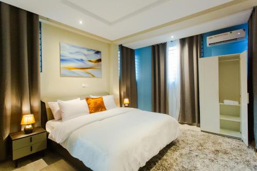 ChantanAccra Luxury Homes @ Achimota的卧室设有白色的床和大窗户