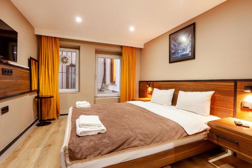 伊斯坦布尔Aram Kerasi Rooms的一间卧室配有一张大床和电视