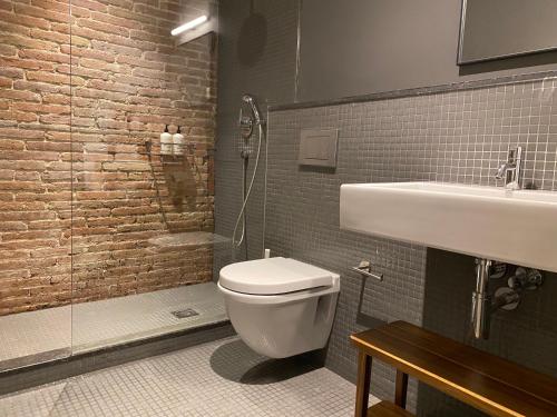 巴塞罗那Uma Suites Pau Claris的浴室配有卫生间、盥洗盆和淋浴。