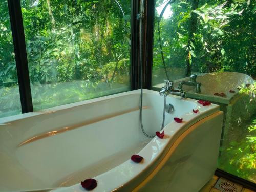 瓜埠斯里乡村别墅的带浴缸的浴室和窗户