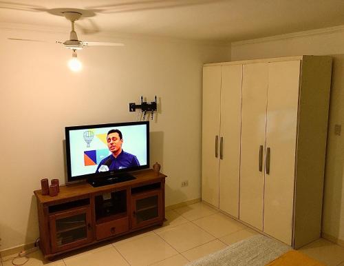 帕拉蒂Cantinho da Bruxa的客厅配有壁橱上的平面电视