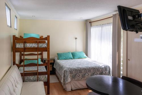 拉塞雷纳Apart Hotel Colors的一间卧室配有一张床和一张双层床。