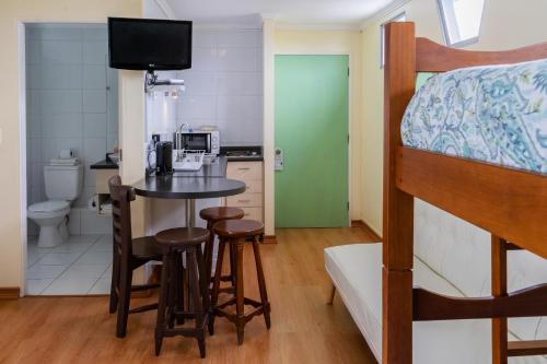 拉塞雷纳Apart Hotel Colors的一间卧室配有一张双层床和一张桌子及椅子。