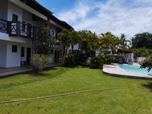科曼达图巴岛Pousada São Nunca的一座带游泳池和棕榈树的房屋的庭院