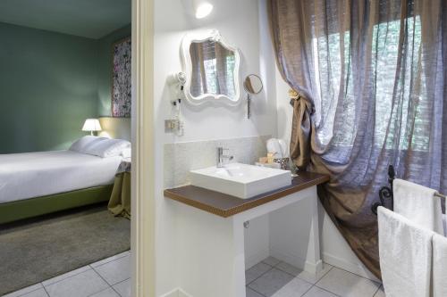 圣阿尔坎杰洛-迪罗马涅曼松毕格蒂住宿加早餐旅馆的一间带水槽、床和镜子的浴室