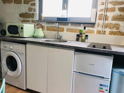 UsCocooning little house in french Vexin的厨房配有水槽和洗衣机