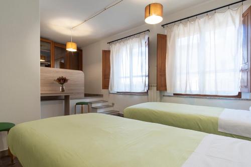 拉努塞伊Locanda Sighimi的酒店客房带两张床和厨房
