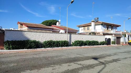 马塔拉斯卡尼亚斯Chalet Matalascañas的一条空的街道,旁边是墙上,有房子