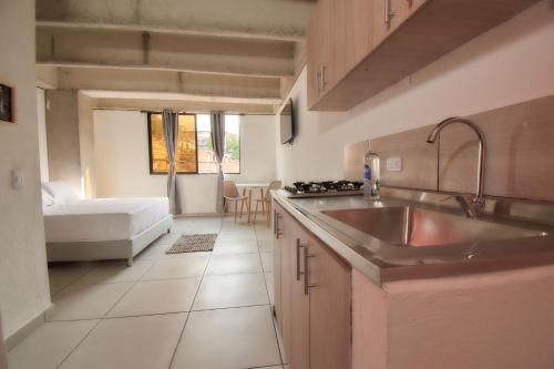 麦德林MANGATA LIVING的一个带水槽的厨房和一张位于客房内的床