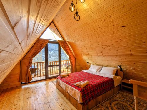 卡兹贝吉Cottage Caucasus的木制客房的一张床铺,设有大窗户