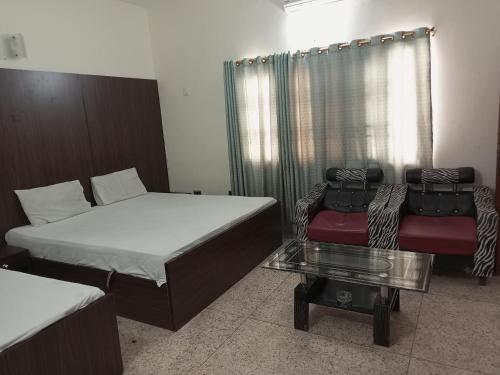 卡拉奇Karachi Guest House & Couple Hotel的客房设有两张床、一张沙发和一张桌子。