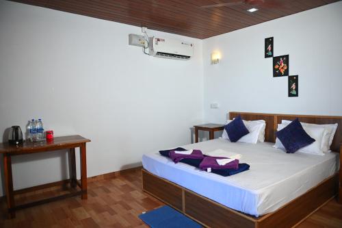 阿贡达Madhu Huts Agonda的一间卧室配有一张带蓝色和紫色枕头的床