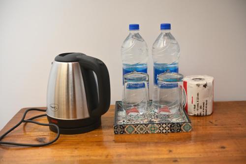 阿贡达Madhu Huts Agonda的咖啡壶和桌子上的两瓶水
