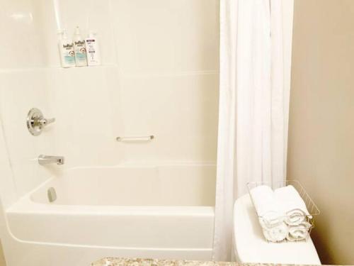 里贾纳NairaVilla: upscale accommodation for groups的白色的浴室设有浴缸和淋浴帘