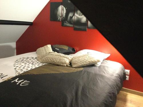 Saint-InglevertDétour d’un soir…的一间卧室配有一张红色墙壁的床